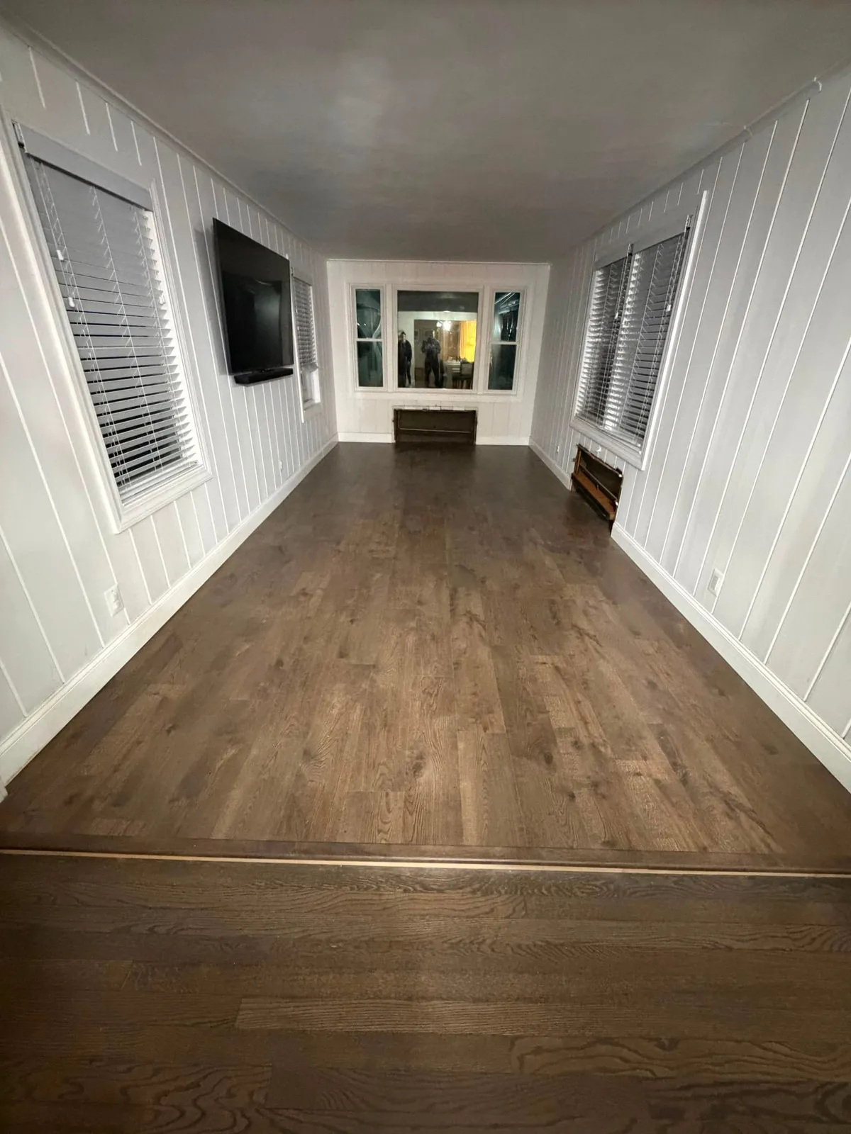 Sunroom with new wood-look plank flooring after installation